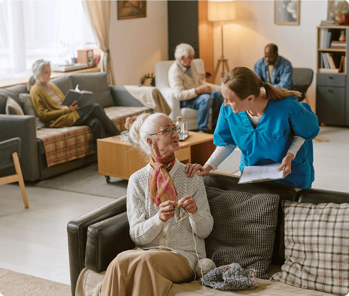 Nurse talking to elderly woman knitting